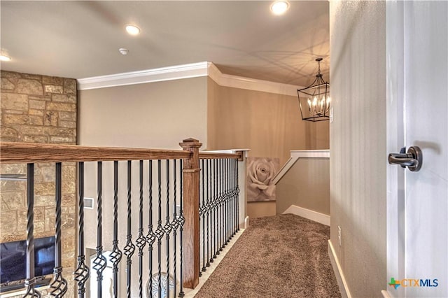 hallway with carpet floors, a chandelier, and ornamental molding