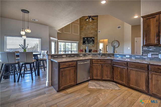 kitchen featuring dishwasher, high vaulted ceiling, sink, ceiling fan, and kitchen peninsula