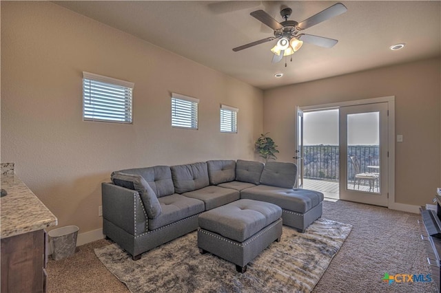 carpeted living room with ceiling fan