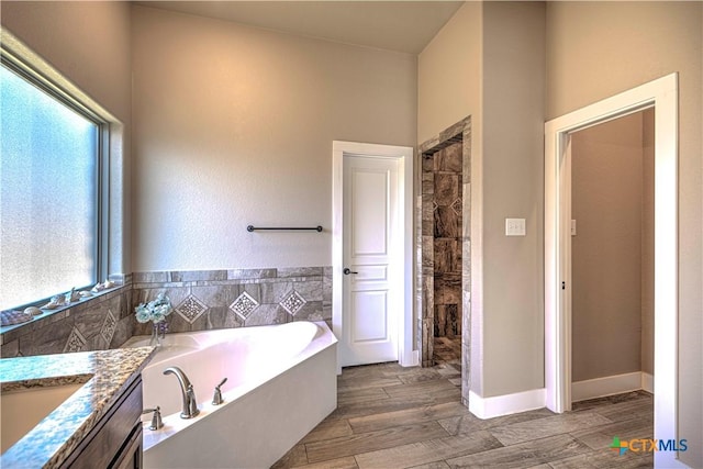 bathroom featuring vanity, plenty of natural light, and independent shower and bath