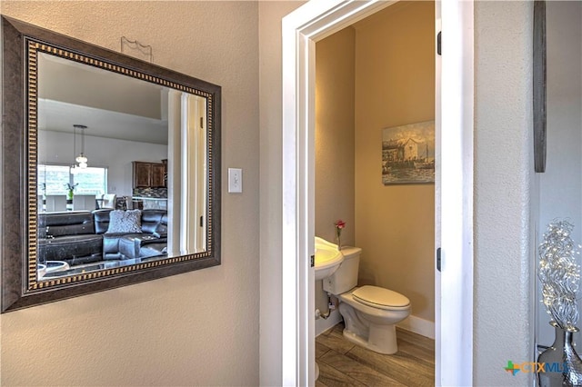 bathroom featuring hardwood / wood-style flooring and toilet