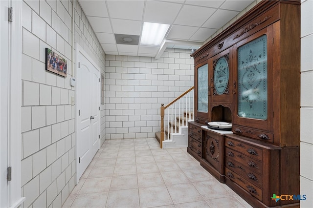 bathroom with tile patterned flooring and a drop ceiling