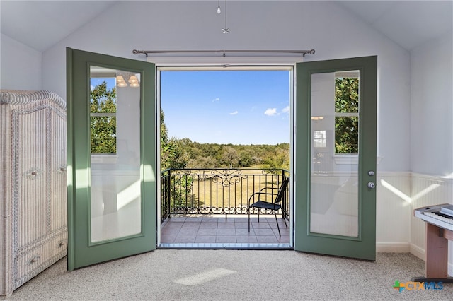 entryway with light carpet, french doors, plenty of natural light, and lofted ceiling