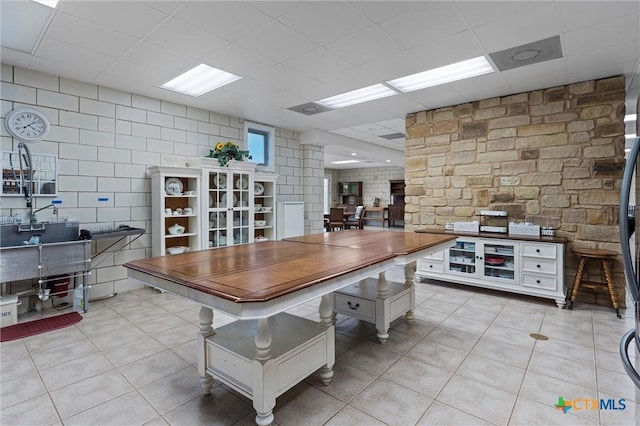 living room with french doors, light tile patterned flooring, and a drop ceiling