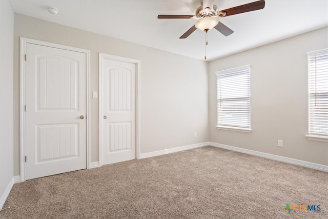 unfurnished bedroom featuring multiple windows and carpet flooring