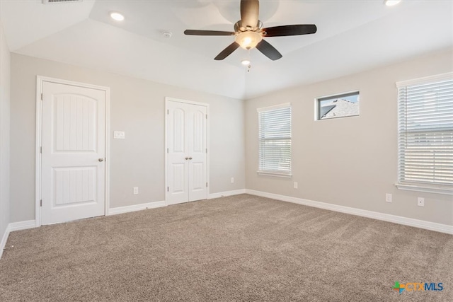 unfurnished room featuring ceiling fan, vaulted ceiling, and carpet floors