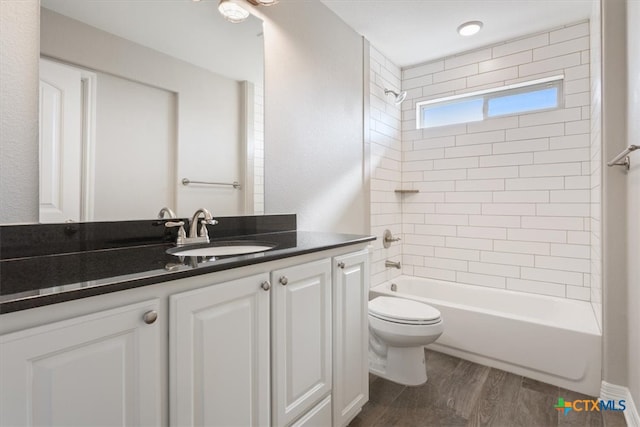 full bathroom with toilet, tiled shower / bath combo, vanity, and hardwood / wood-style flooring