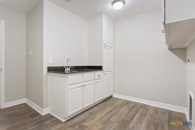 interior space with white cabinets, dark hardwood / wood-style floors, and sink