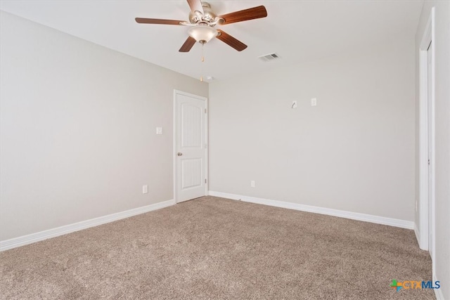 carpeted spare room featuring ceiling fan