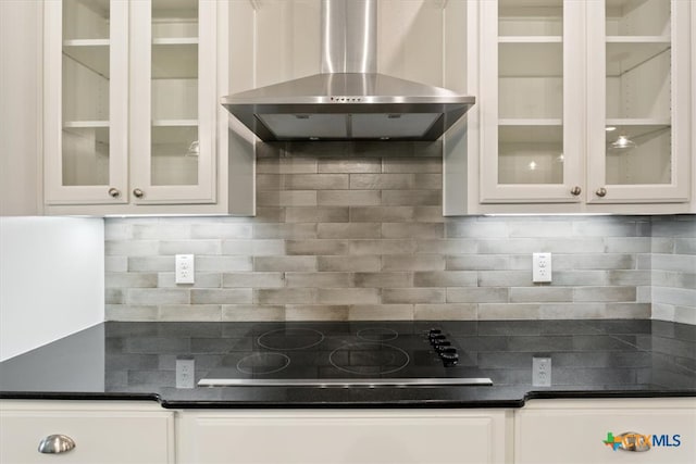 kitchen featuring white cabinetry, black stovetop, and wall chimney exhaust hood