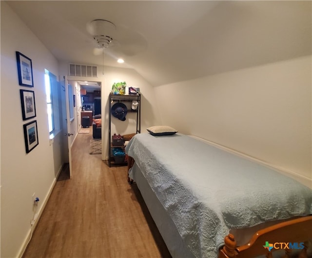 bedroom featuring hardwood / wood-style floors, ceiling fan, and vaulted ceiling