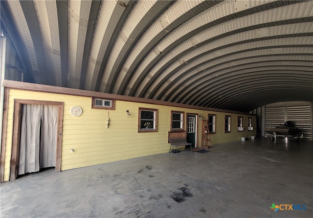 miscellaneous room with concrete flooring and vaulted ceiling