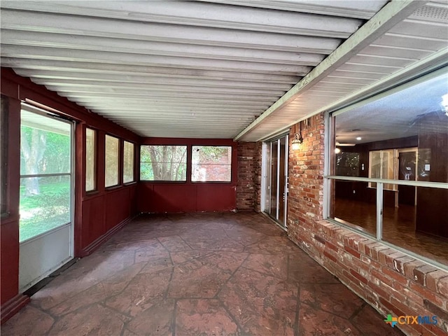 2110 Pamela Rd, Temple, TX 76502 - unfurnished sunroom featuring stone finish floors and brick wall