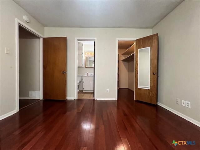 2110 Pamela Rd, Temple, TX 76502 - unfurnished bedroom with dark wood-type flooring, a closet, baseboards, and connected bathroom