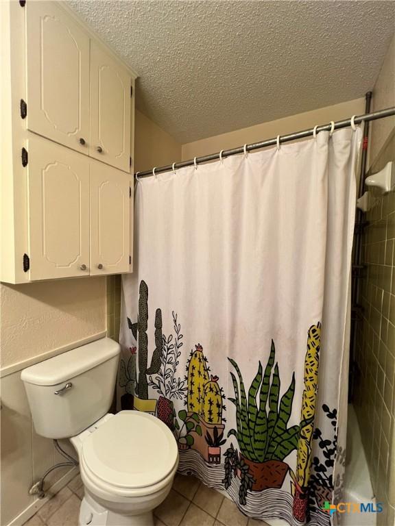 2110 Pamela Rd, Temple, TX 76502 - bathroom with a textured ceiling, toilet, tile patterned flooring, and shower / tub combo with curtain