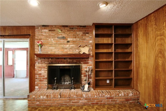 2110 Pamela Rd, Temple, TX 76502 - unfurnished living room featuring wooden walls, a textured ceiling, and a brick fireplace
