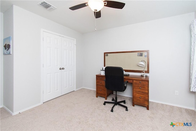 carpeted office space featuring baseboards, visible vents, and a ceiling fan