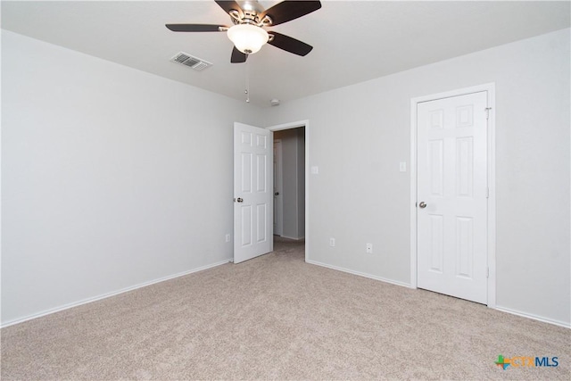 unfurnished bedroom featuring light carpet, a ceiling fan, visible vents, and baseboards