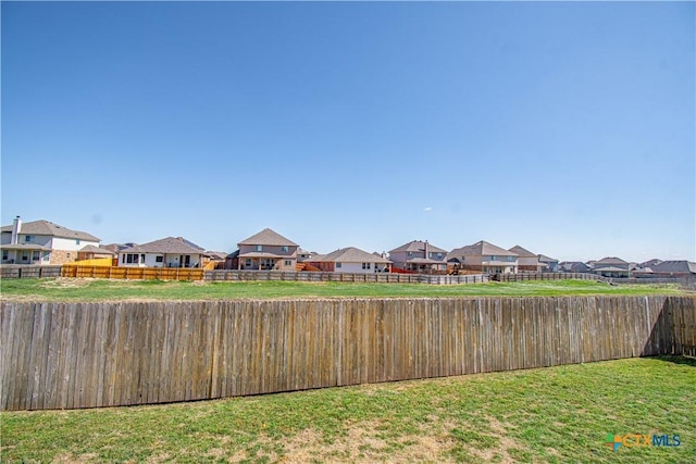 view of yard featuring a residential view and a fenced backyard