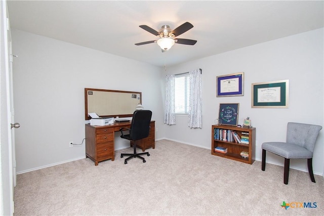 home office with light carpet, ceiling fan, and baseboards