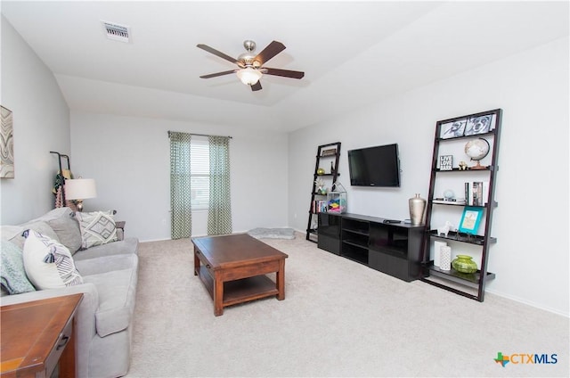 carpeted living room featuring baseboards, a tray ceiling, visible vents, and a ceiling fan