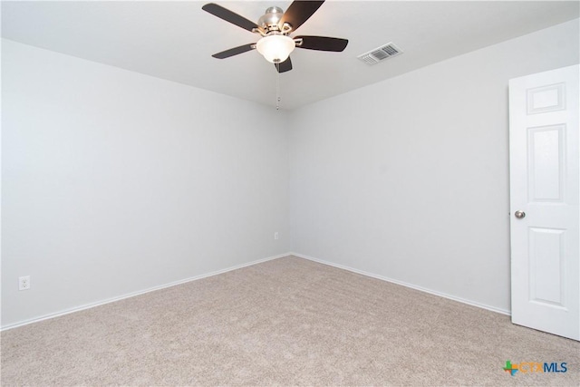 spare room with carpet floors, visible vents, baseboards, and a ceiling fan