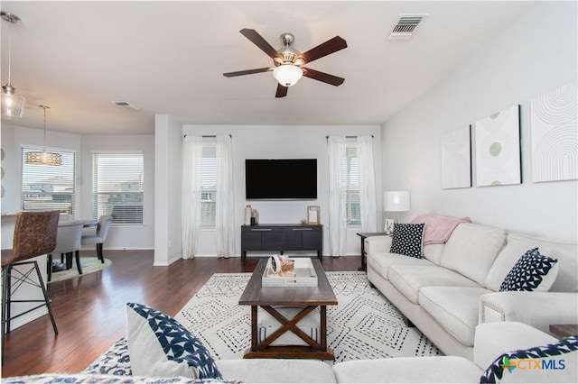 living room with a ceiling fan, baseboards, visible vents, and wood finished floors