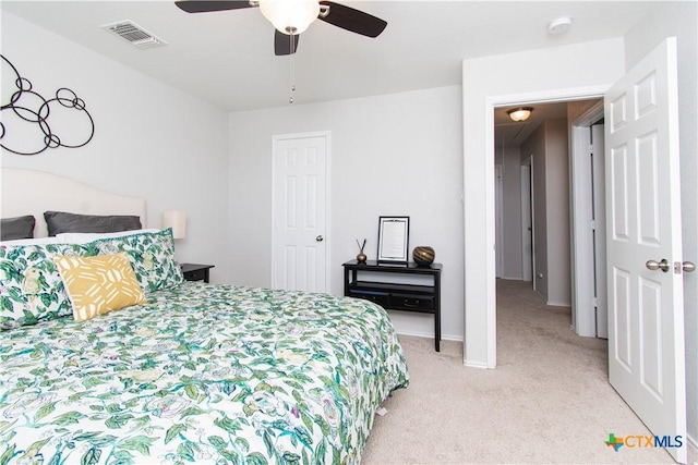 bedroom with light carpet, ceiling fan, visible vents, and baseboards