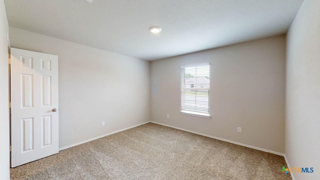 carpeted spare room with baseboards