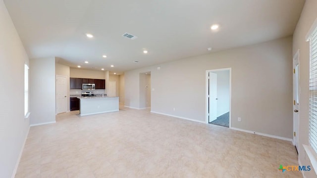 unfurnished living room featuring recessed lighting, visible vents, and baseboards