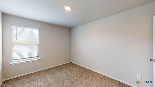 unfurnished room with carpet floors, a wealth of natural light, and baseboards