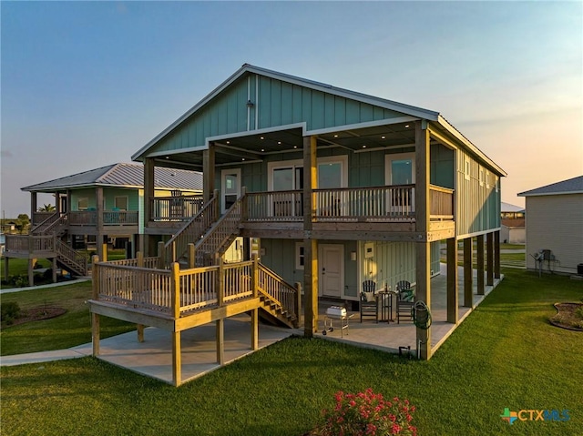 121 Bufflehead Ln, Rockport, TX 78382 - back of property with a patio, stairs, a yard, and board and batten siding