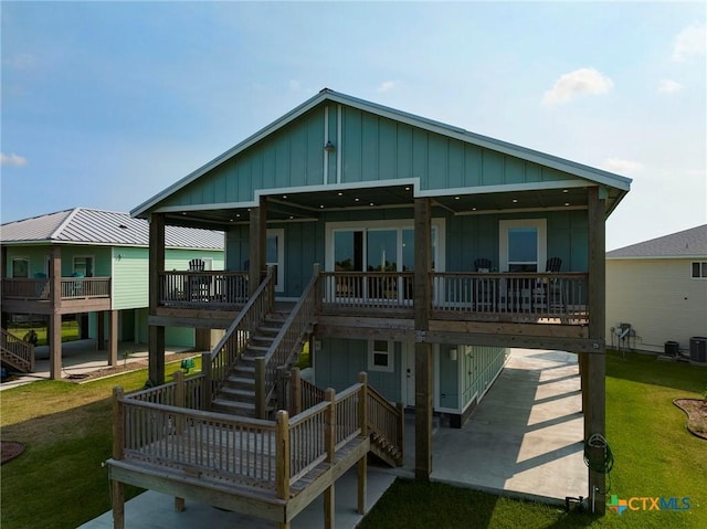 121 Bufflehead Ln, Rockport, TX 78382 - view of front of home featuring board and batten siding, a front yard, and stairway