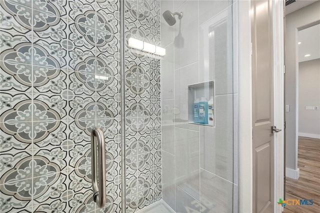 121 Bufflehead Ln, Rockport, TX 78382 - full bathroom featuring tiled shower, wood finished floors, and baseboards