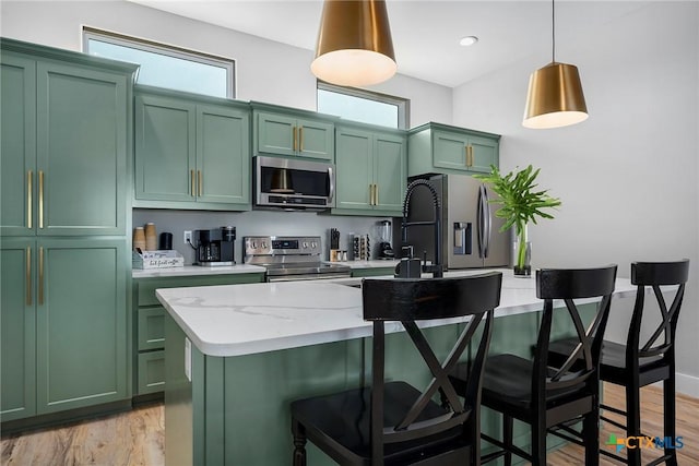 121 Bufflehead Ln, Rockport, TX 78382 - kitchen with green cabinets, stainless steel appliances, light wood-type flooring, and a kitchen island with sink