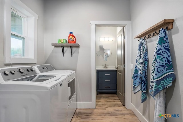 121 Bufflehead Ln, Rockport, TX 78382 - washroom featuring washer and dryer, light wood-style floors, and baseboards