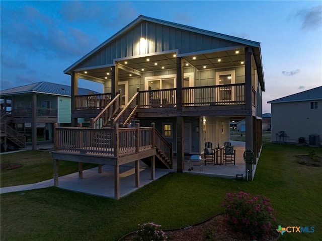 121 Bufflehead Ln, Rockport, TX 78382 - rear view of property featuring a patio area, board and batten siding, stairs, and a yard