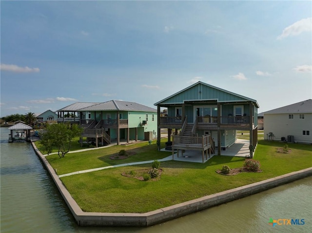 121 Bufflehead Ln, Rockport, TX 78382 - view of front facade with stairway, a deck with water view, and a front lawn