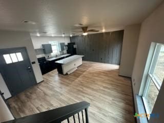 kitchen featuring a center island, light countertops, ceiling fan, and light wood-style flooring