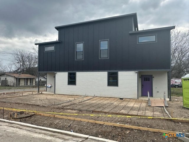 rear view of house with a patio and board and batten siding