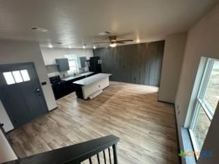 living area with light wood-type flooring and ceiling fan