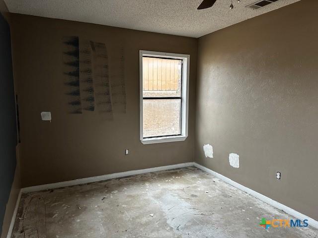 unfurnished room with concrete flooring, a textured ceiling, and ceiling fan