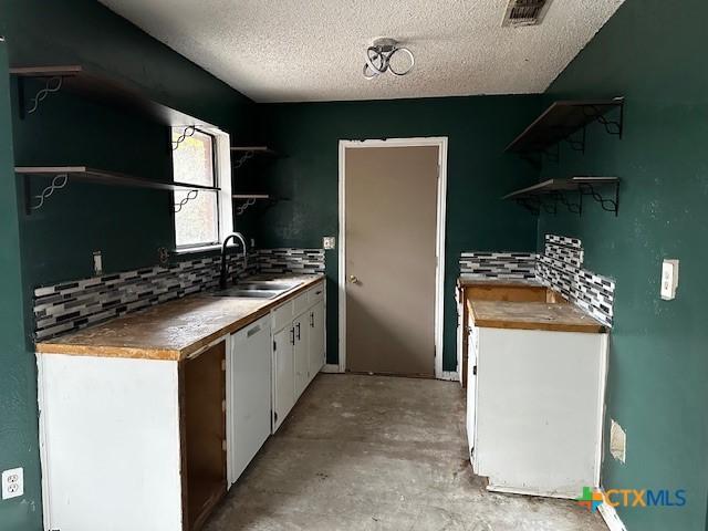 kitchen with dishwasher, sink, backsplash, a textured ceiling, and white cabinets