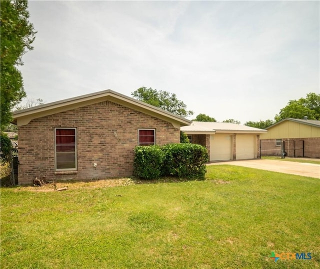 1906 N 60th St, Killeen, TX 76543 - ranch-style house featuring brick siding, driveway, a front yard, and a garage
