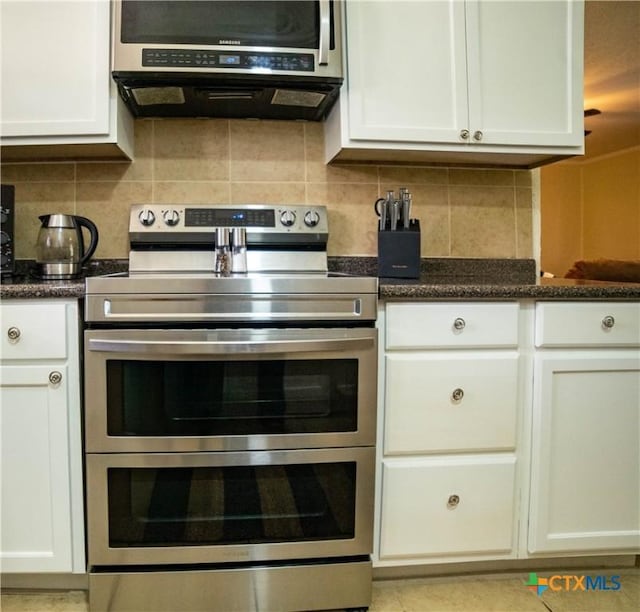 1906 N 60th St, Killeen, TX 76543 - kitchen featuring double oven range, extractor fan, backsplash, and white cabinets