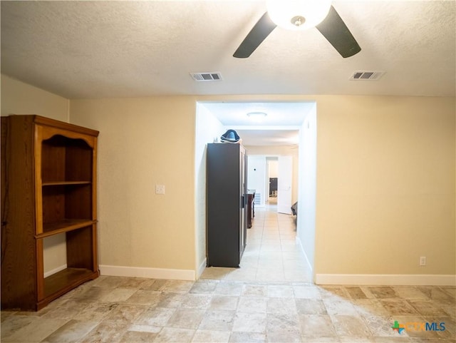 1906 N 60th St, Killeen, TX 76543 - hallway featuring a textured ceiling, light stone finish flooring, and baseboards
