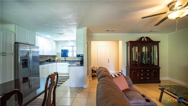 1906 N 60th St, Killeen, TX 76543 - living room with light tile patterned floors, ceiling fan, crown molding, baseboards, and a textured ceiling