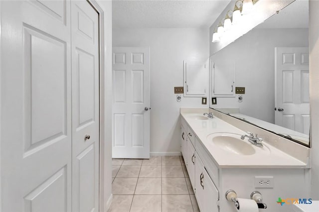 108 Bridle Ln, Victoria, TX 77904 - full bath featuring double vanity, tile patterned flooring, a closet, a textured ceiling, and baseboards