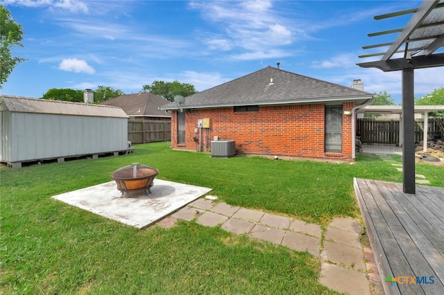 108 Bridle Ln, Victoria, TX 77904 - view of yard featuring an outdoor fire pit, central AC, a wooden deck, and a patio