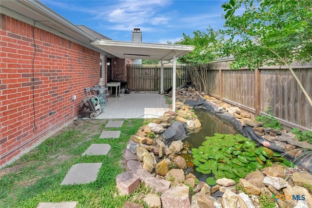 108 Bridle Ln, Victoria, TX 77904 - fenced backyard with a garden pond and a patio